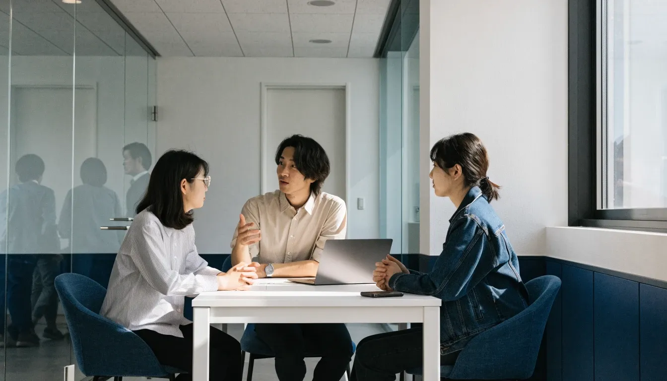 明るい会議室で打ち合わせをする3人